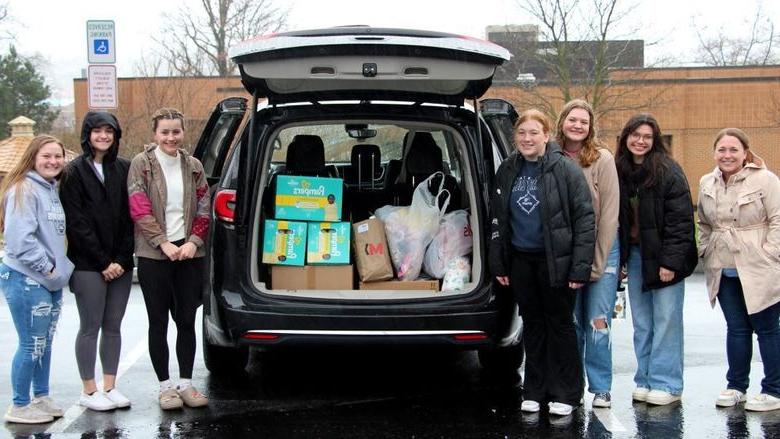 Members of the HDFS club at 365英国上市杜波依斯分校 stand next to the vehicle loaded with their donation items prior to their trip to the Hello Neighbor location in Pittsburgh.